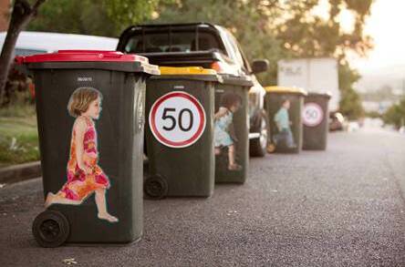 WARNING SIGNS:  Life-sized stickers on wheelie bins warn motorists to slow down. 