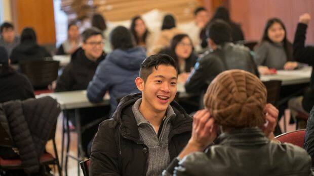 Brandon Hung makes the most of his four minutes at a Melbourne University speed friending event. Photo: Simon Schluter
