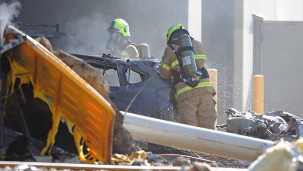Emergency services personnel are seen at the scene of a plane crash in Essendon. Photo: Joe Castro