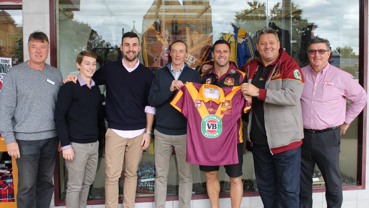 WINNING FEELING: Country Origin player Michael Gordon and former player Steve "Blocker" Roach present Peter Segal and Blowes staff with the prize jersey.