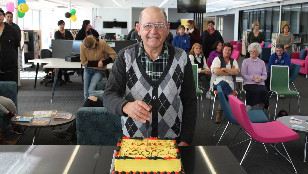 TAKES THE CAKE: David Maynard, of the Mudgee Local Aboriginal Land Council board of directors, cuts the NAIDOC Week cake at the TAFE Open Day.
