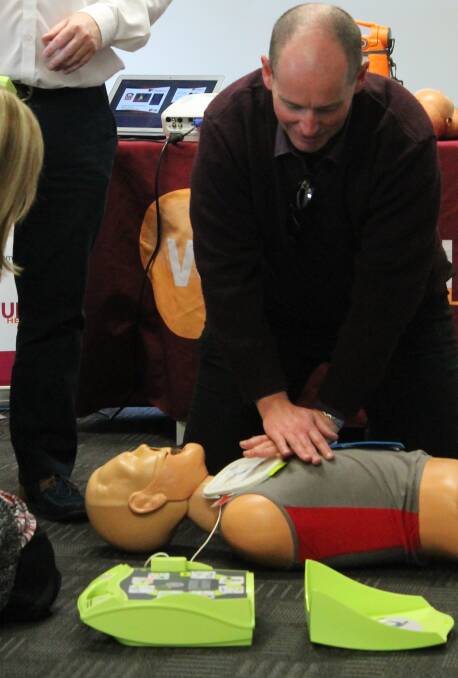 TAKE HEART: Mudgee High School principal Wayne Eade tries out the training Automated External Defibrillator at the launch of Here For Hearts on Tuesday. 