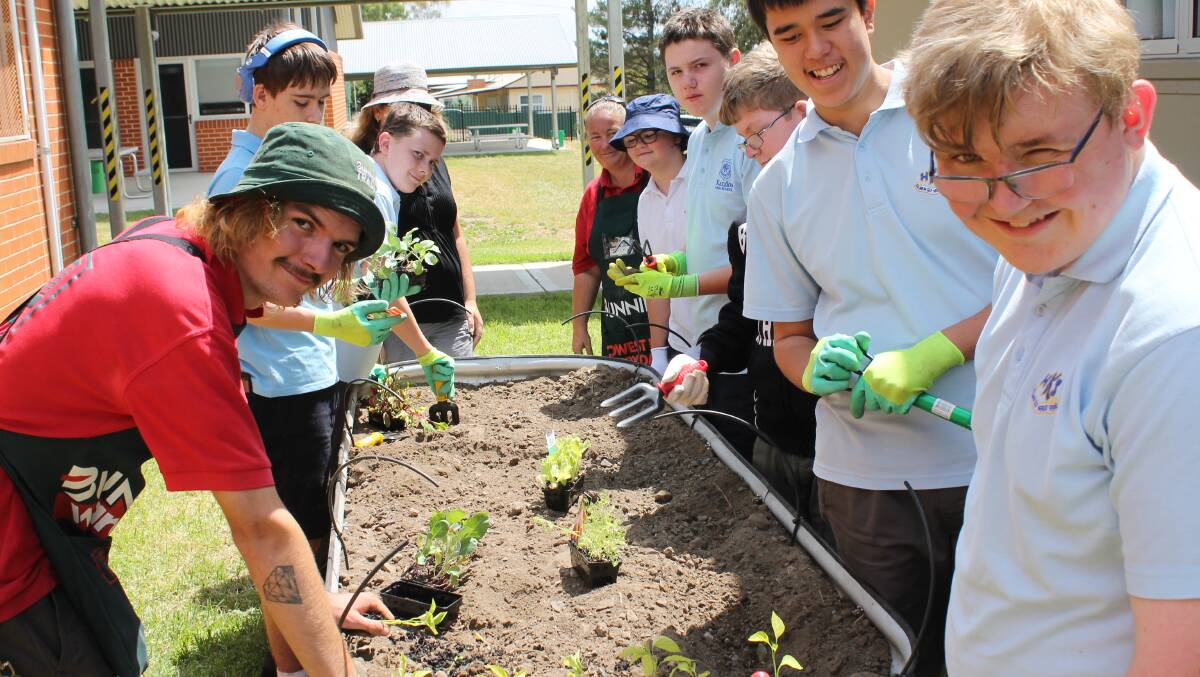Bunnings Mudgee's Gaven Bradford and Kerry Miller help Kandos High School students build up their vegie garden.