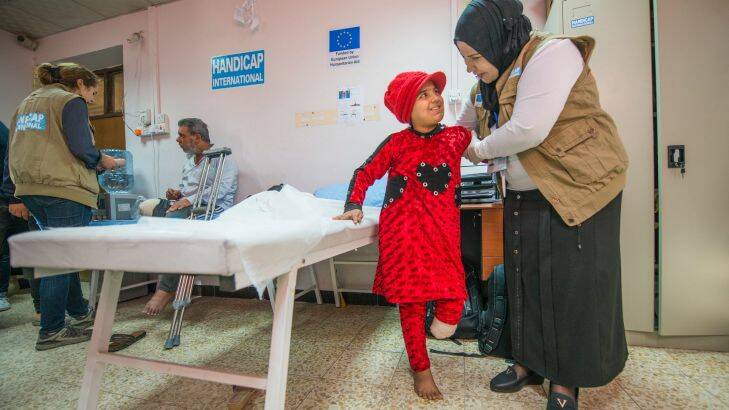 Nada undergoes physiotherapy at the EU-funded Muharabeen primaryhealthcare centre in East Mosul, while her father is treaded nearby. Credit Peter Biro/ECHO/EU