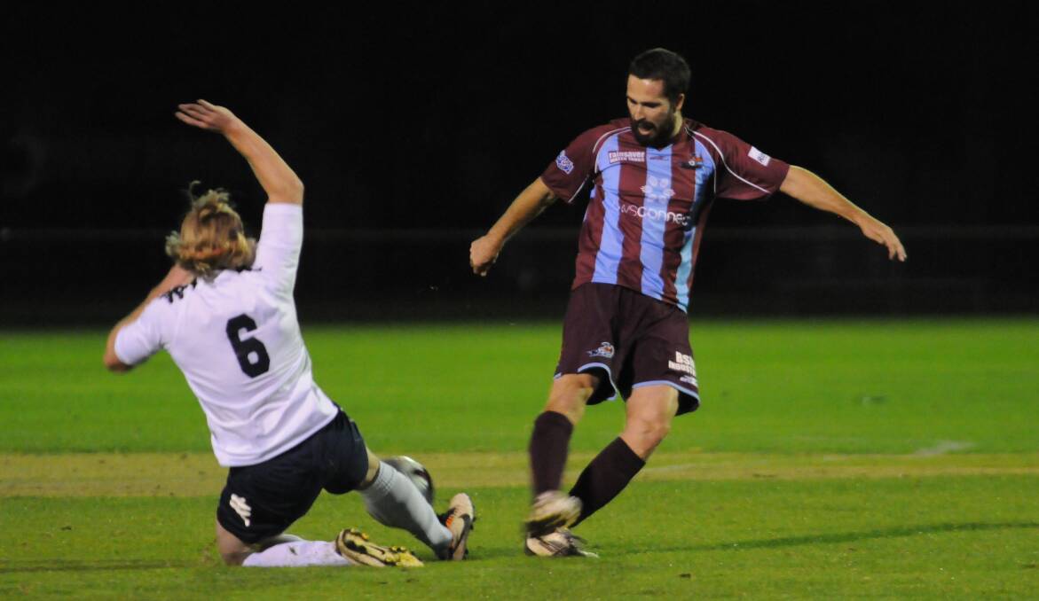 OPENS: Western Mariners' Blake Collins slides in for a tackle on Hawkesbury FC's David Gardiner. Photo: JUDE KEOGH