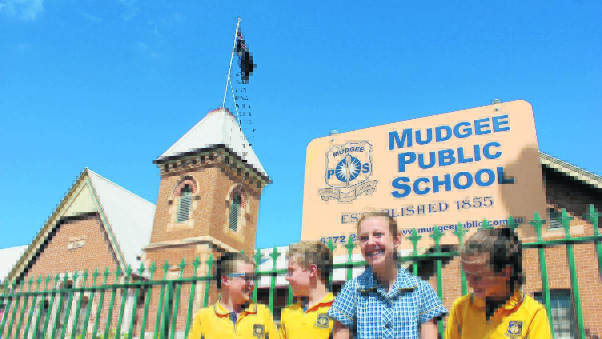 Mudgee Public School’s iconic flag has been anonymously returned a month after it was taken. Pictured with it are students Caleb Begg, Oliver Manners, Makayla Rankin and Paige Robertson.	