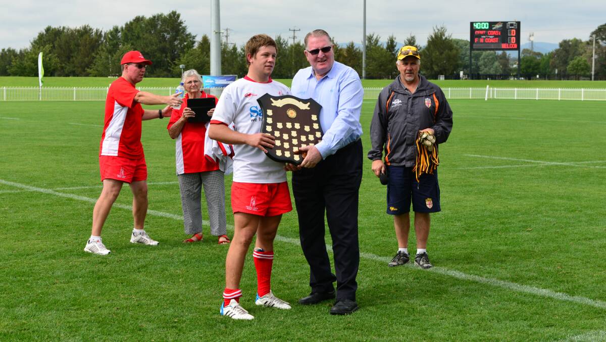 The Central North colts captain receives the tier-two NRMA Colts Shield from NSW Country Rugby Union life member Laurie Maher.