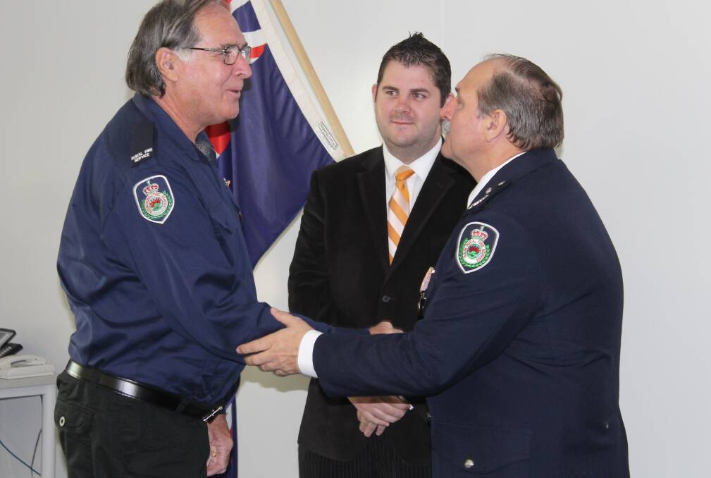 NSW RFS Assistant Commissioner Stuart Midgley presents Bob Ford of the Cooks Gap Brigade with the National Medal.