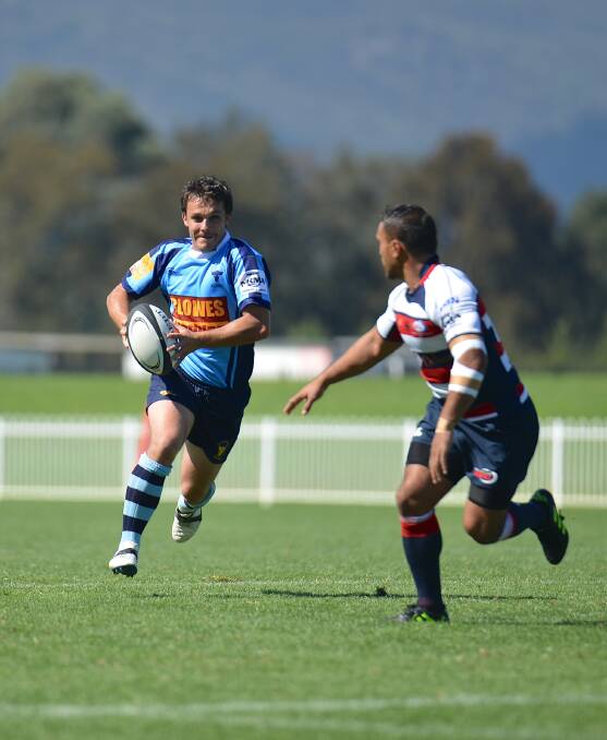 Central West's John Rathbone looks to dodge Newcastle's defence.
