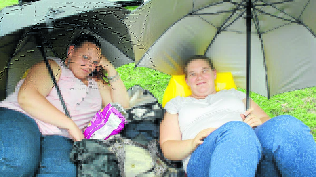 Sarah Harris and Laura Johnson took shelter while waiting for their favourite band, Eskimo Joe, to perform.