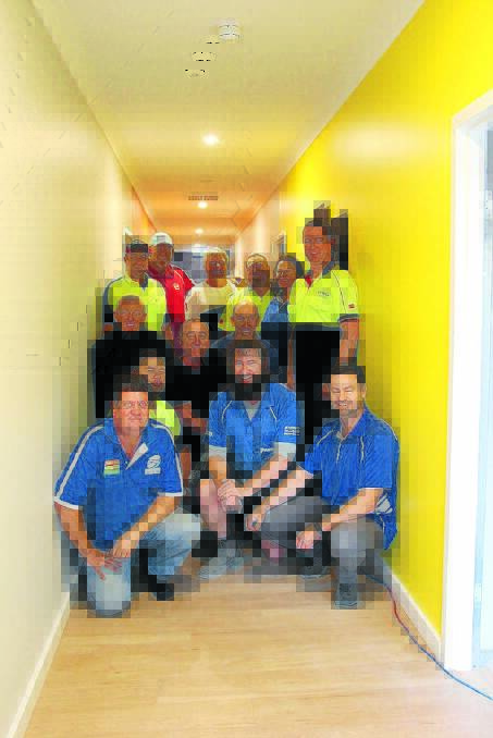 The team from Petries Mitre 10 and CSR with tradesman Marty Turner at the new Lifeskills Plus centre where they spent Thursday building three new rooms for the organisation.