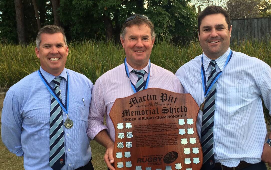 Justin McCarney (left) with the CCC coaching squad and Martin Pitt Memorial Shield after the historic tournament run.