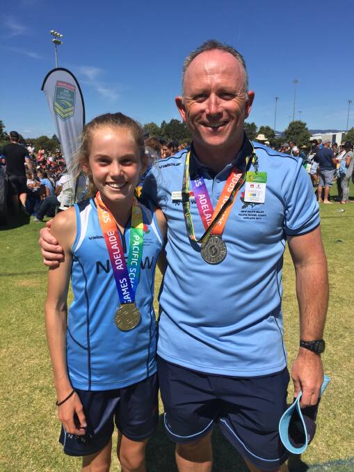 ST MATTS MENTOR: Alesha Bennetts celebrated her touch football medal alongside St Matthew's under 12 boys coach Barry Neaverson. Photo: Supplied 