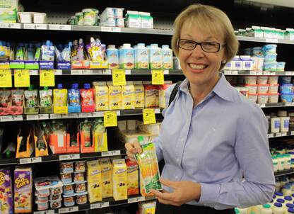 Nutritionist Penny Small looks over the many options available in the supermarket’s dairy section. 
