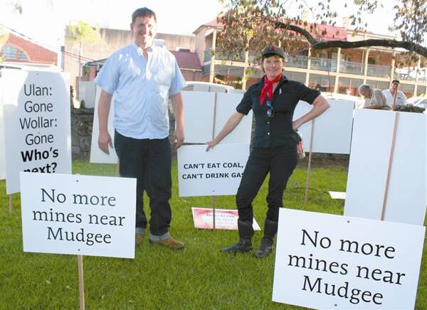 THE OTHER SIDE: Organisers of the alternative mining conference, Mudgee Mining: The wHole Story, Craig Shaw and Nell Schofield, among signs planted in Lawson Park on Tuesday. 	210312\rmrally