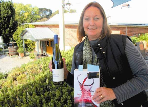 Robert Oatley Vineyard cellar door manager Amanda Lyons with James Halliday’s 2013 Australian Wine Companion, in which the winery receives a red five-star rating, and the 2011 Robert Oatley Great Southern Riesling, which the book awarded 94 points. 	310712/Oatley/28