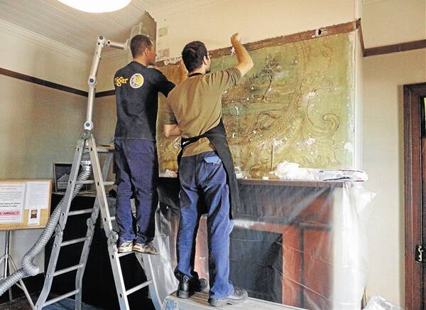 Conservators Adam Godijn and Matteo Volonté at work on the mural in Rylstone’s Bridge View Inn. Members of the public can visit the inn this Sunday to inspect the progress of the conservation. 	210312/mural/ICS