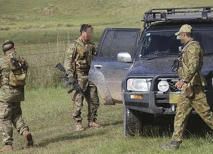 Heavily armed police search for Malcolm Naden near Nowendoc yesterday.