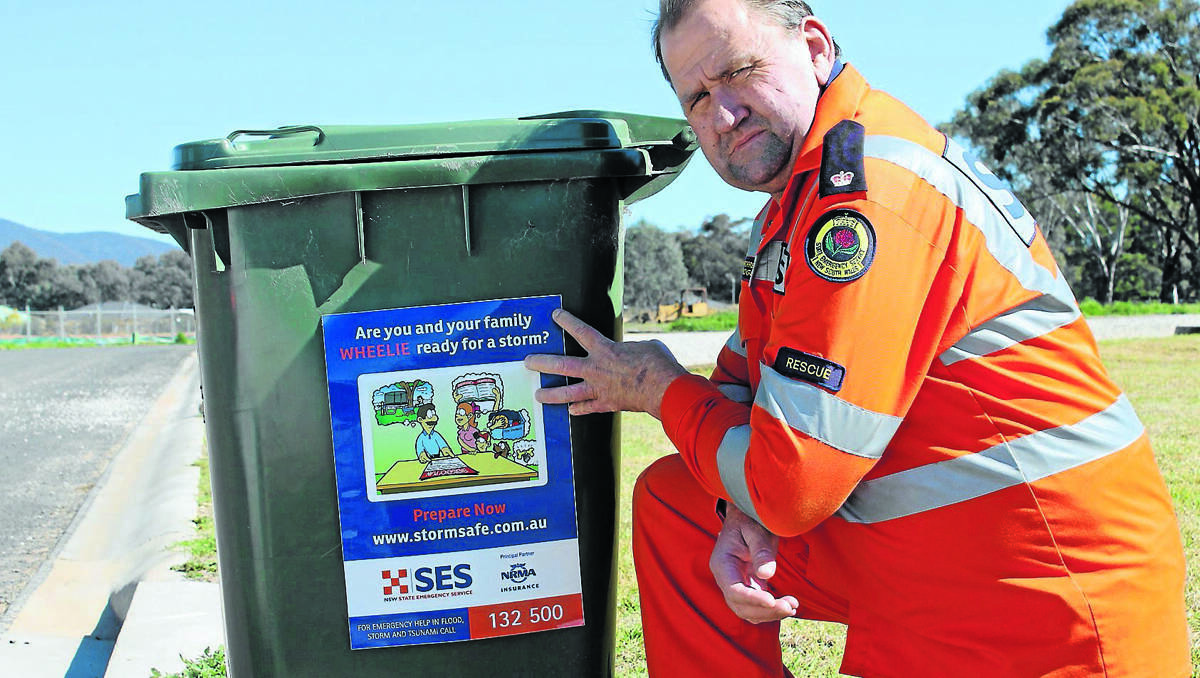 NOW WHEELIE LISTEN: Mudgee SES Unit Controller Ian Forrester pictured with one of the wheelie bin stickers local volunteers will be handing out this Saturday morning during their door knock of the town’s most flood prone areas.