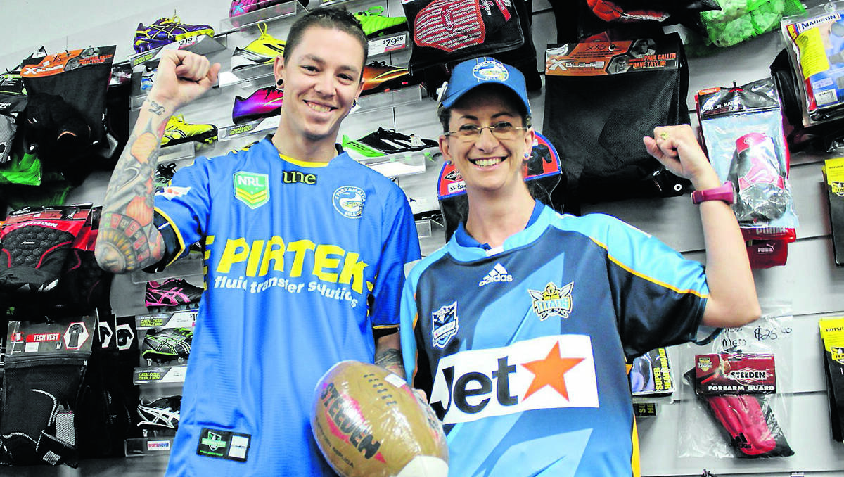 DRESS UPS: Sportspower Mudgee’s Blake Joseph and Marcia Rawlinson in Parramatta Eels and Gold Coast Titans gear ahead of the NRL match at Glen Willow on May 26. Mid-Western Regional Council is asking businesses to dress their shop fronts leading up to the game. PHOTO BY DARREN SNYDER