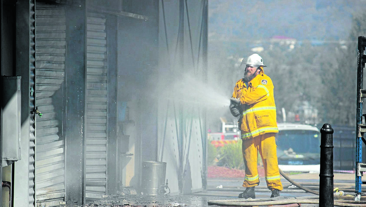 BURNT: A Rural Fire Service volunteer extinguishes the fire that burnt facilities at Glen Willow Regional Sporting Complex on Monday. PHOTO BY DARREN SNYDER