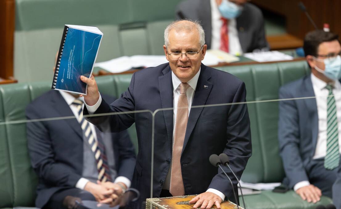 NET ZERO: Prime Minister Scott Morrison brandishes a copy of the federal government's emissions plan. Picture: Sitthixay Ditthavong