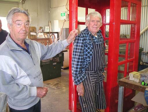 NOSTALGIA: Geoff Charlsworth and Doug Cook, who were on the team, try to use threepence to make a call. Photo: The Men's Shed.