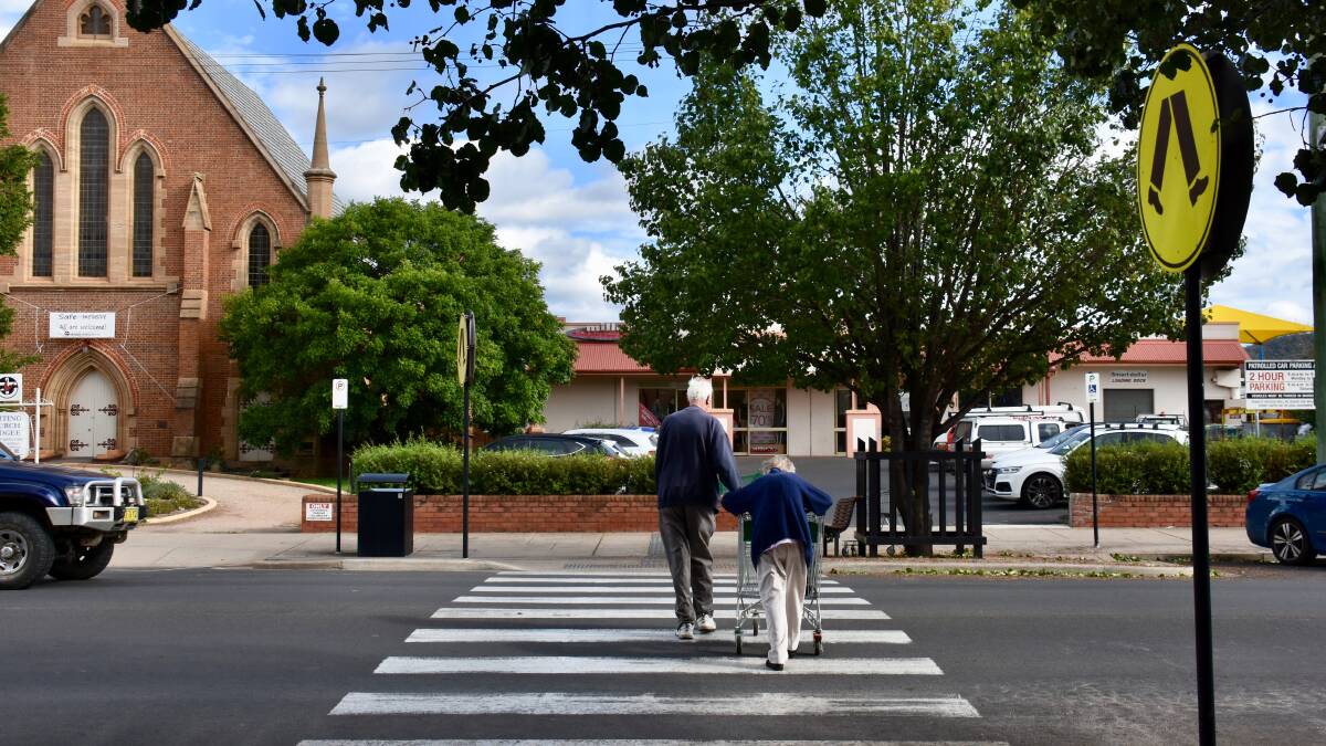 An elderly couple cross the street after exiting Woolworths. Photo: Nicolas Zoumboulis