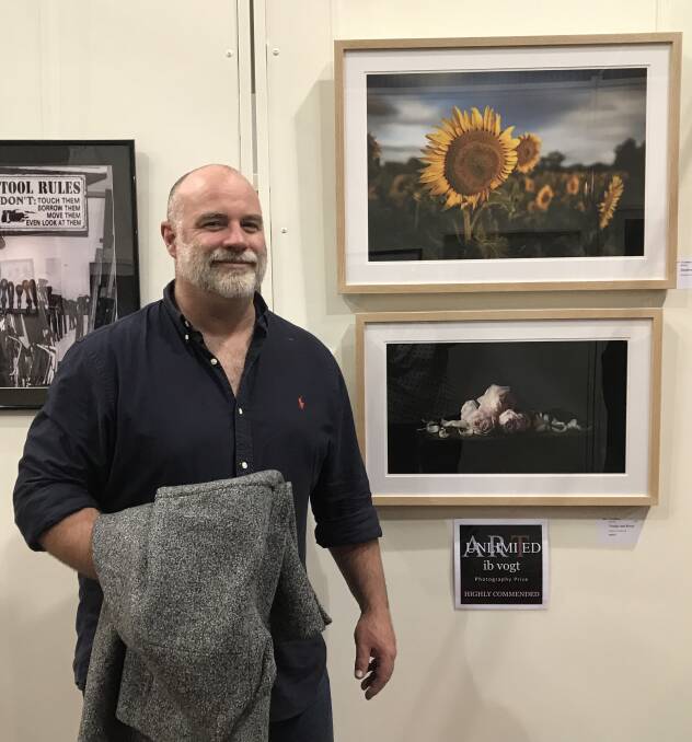 HAPPY: Photographer Tim White stands next to his piece, Trudge and Roses, that was Highly Commended at Art Unlimited. Photo: Jude Morrell