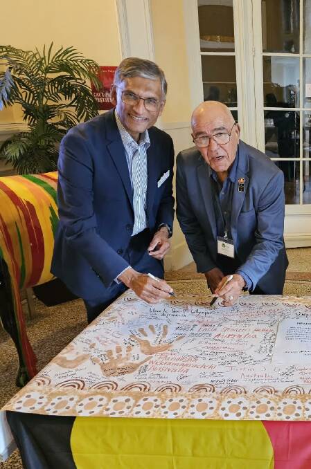 Wiradjuri Elder Uncle Hewitt Whyman signs the statement with IofC President, Dr President Gerald Pillay. Picture supplied