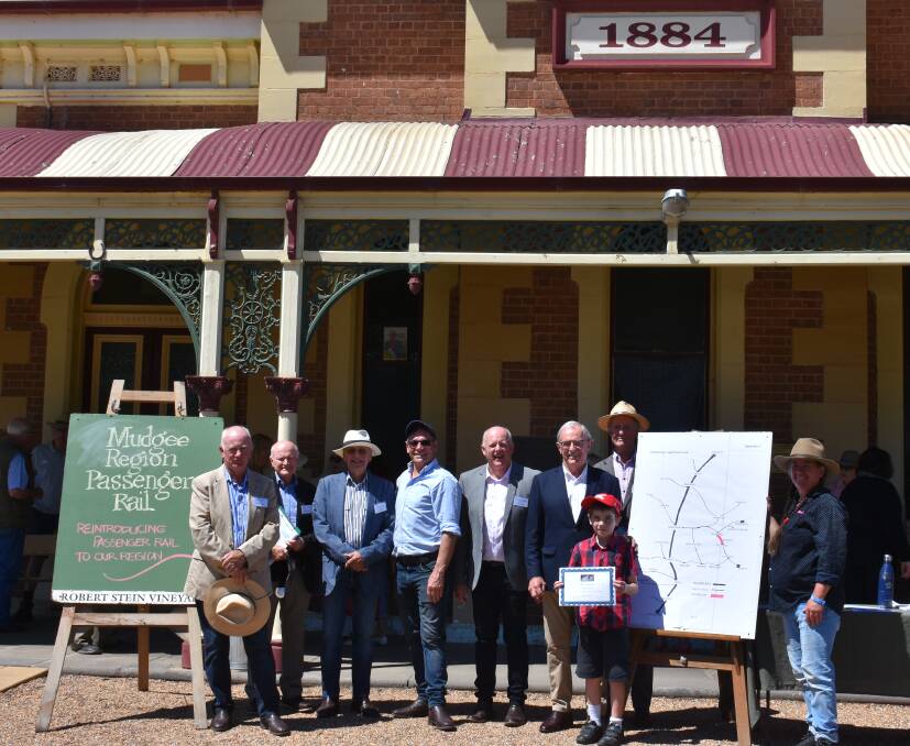 BRING THEM BACK: The seven Mudgee Region Passenger Rail Inc members with locals Adam and Simone Kurtz (right) in front of the Mudgee Train Station. Picture: JAY-ANNA MOBBS