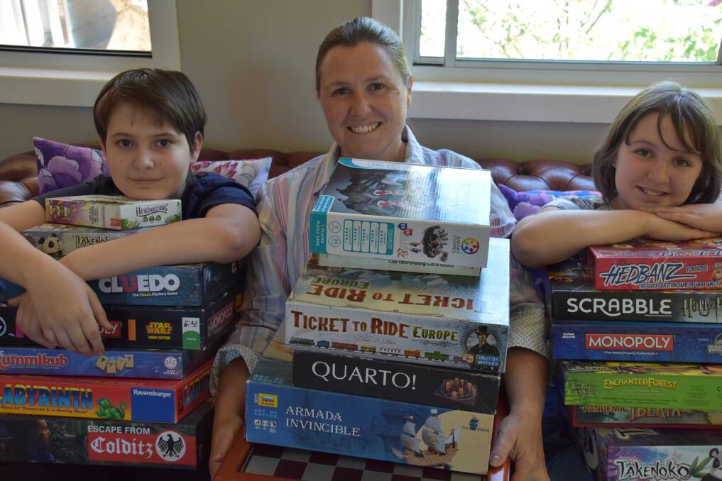 BOARD GAMERS: Trina Brown (middle) says all sports are important hence her collection of board games held by Kalani and Pyper. Photo: Jay-Anna Mobbs
