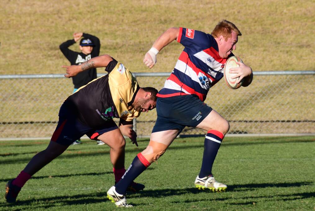 MAKING A RUN FOR IT: Mudgee's David Smith escapes the grip of a Rhino and makes a dash for a five pointer. Photo: Amy McIntyre