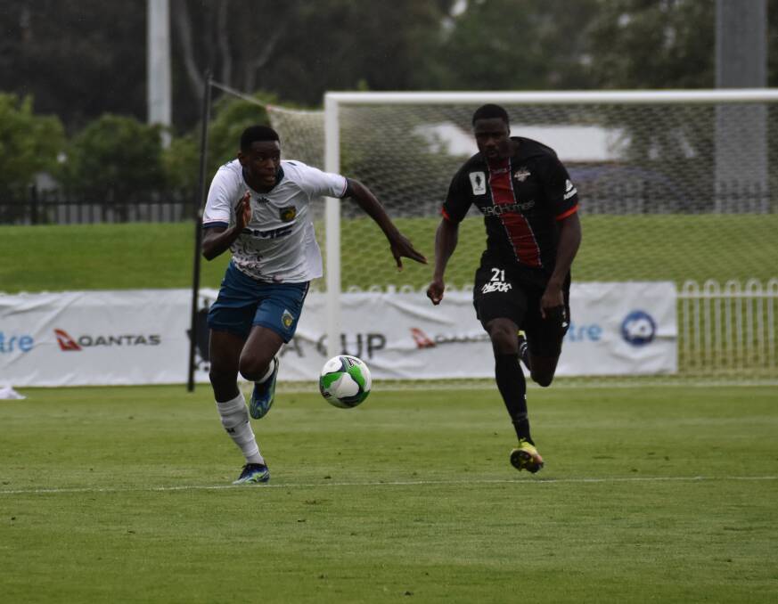 TIGHT TUSSLE: Central Coast Mariners' Beni Nkololo attempting to claim possession of the ball before Blacktown City's Charles Mendy. Picture: JAY-ANNA MOBBS