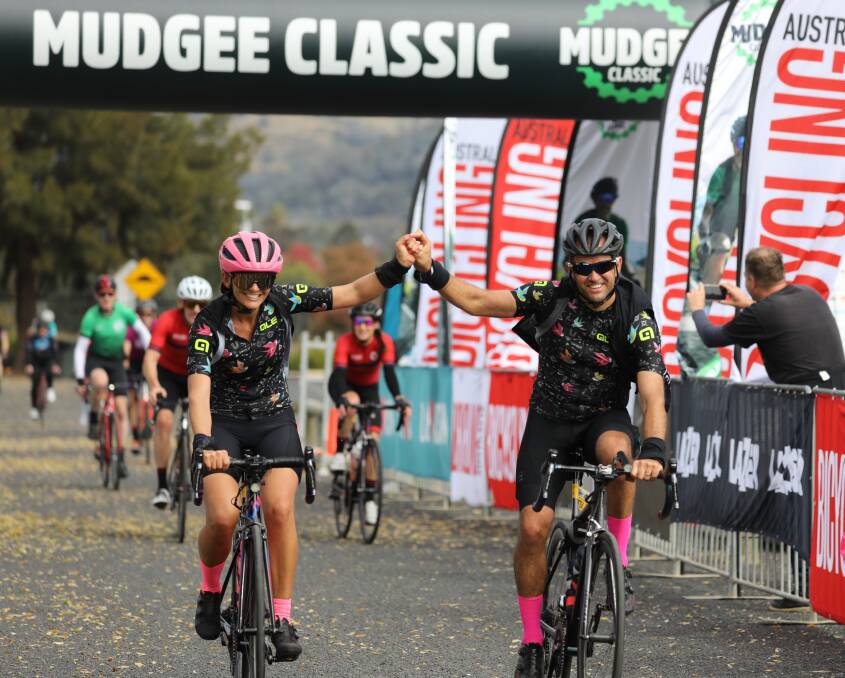 CYCLING: Riders hold hands as they cross the Mudgee Classic finish line in 2021. Picture: SIMONE KURTZ