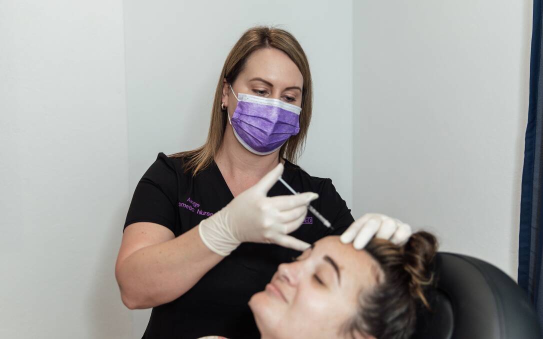 Beauty Reclaimed owner and nurse, Angela Winters administering an injectable with a client. Picture: Marianna Photography