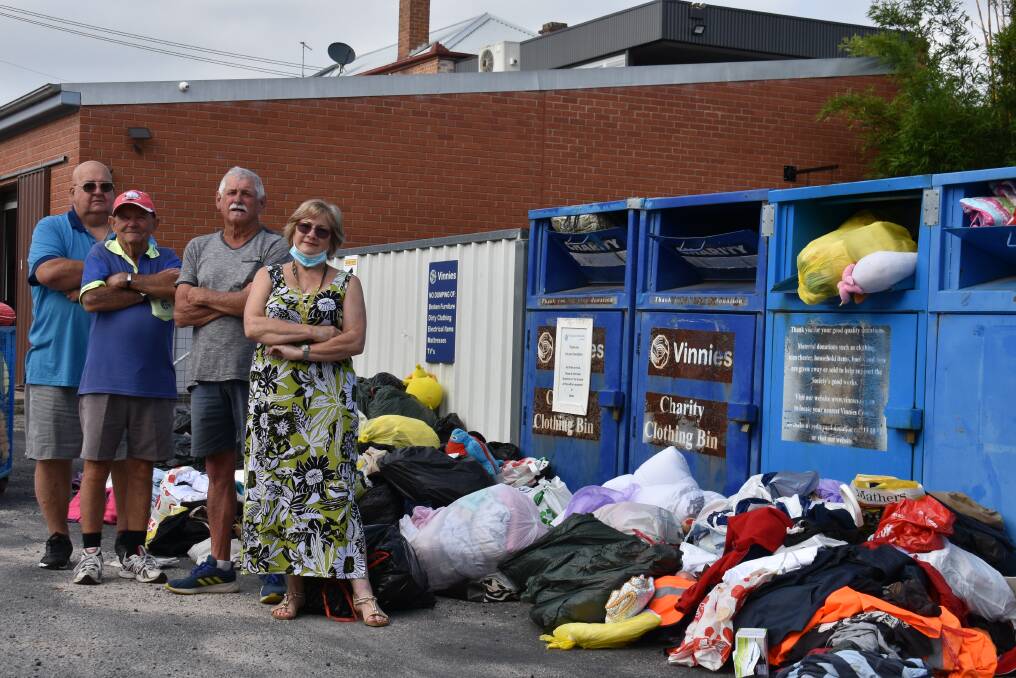 RANSACKED: Chris Wyllie, Ray Sebire, Paul Douglas and Carol Jones in front of the donations that were dumped over the weekend at Mudgee's Vinnies. Picture: JAY-ANNA MOBBS