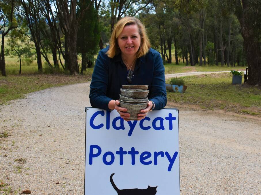 CREATIVE: Catherine Sykes holding some of her bowls in front of the Claycat Pottery sign. Picture: JAY-ANNA MOBBS