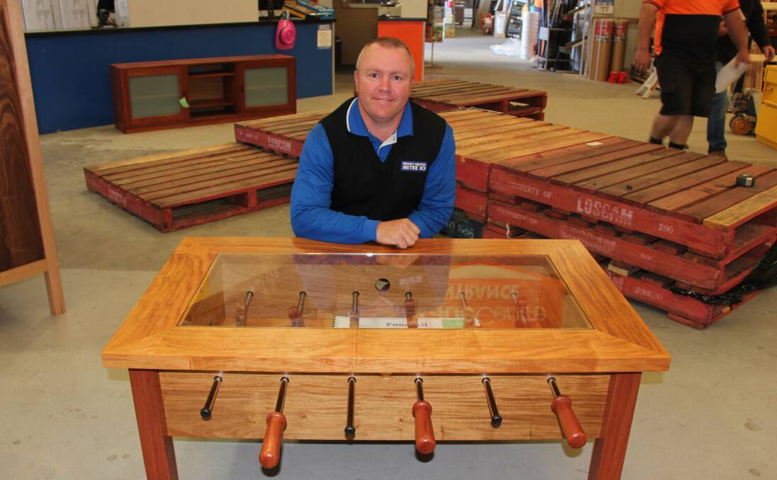 Fun and functional:  Mitre 10 Mudgee store manager Jason Brown with a foosball coffee table by a local student, part of the School Trade Awards. 