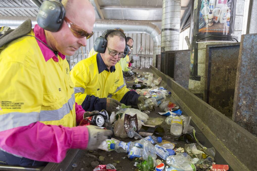 Netwaste Mudgee employees sort through the recycling. 