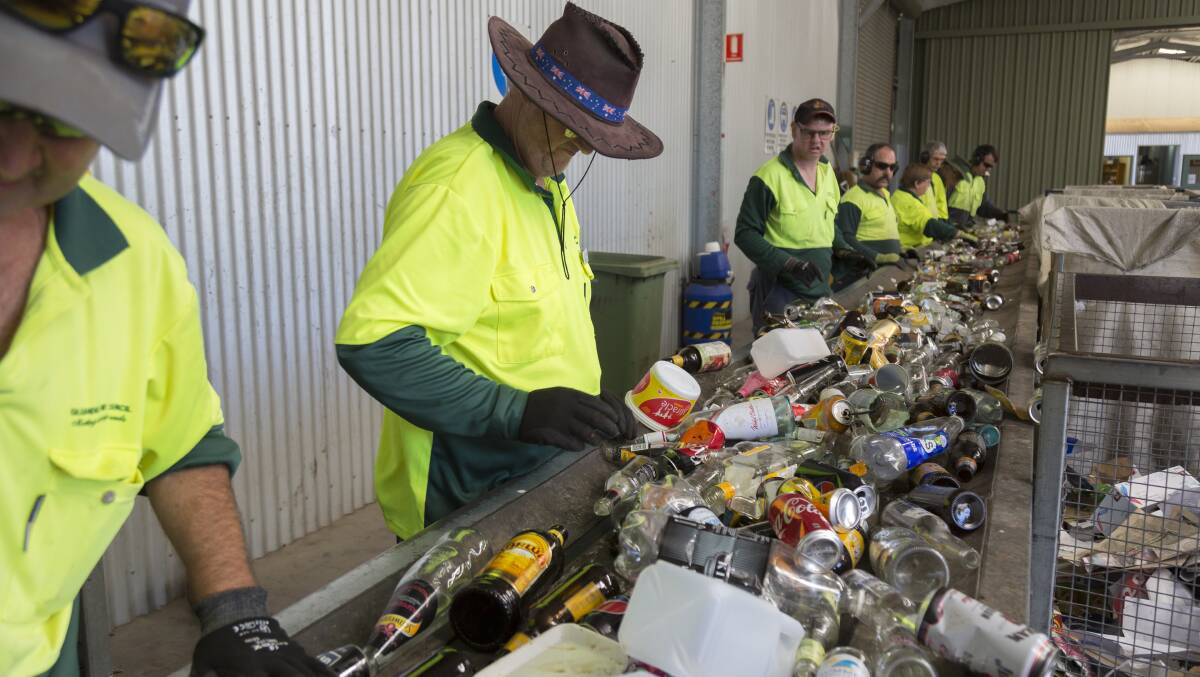 Employees at Netwaste Gilgandra sorting through the recycling materials. 