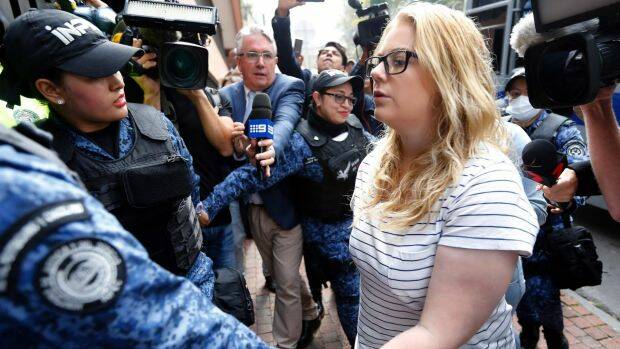Cassandra Sainsbury is escorted by police to a court hearing in Bogota, Colombia. Photo: AP
