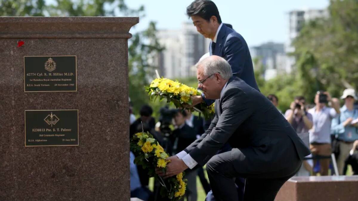Mr Abe lays a wreath along with Mr Morrison. The Japanese PM is on a two-day visit to Australia. Photo: AP