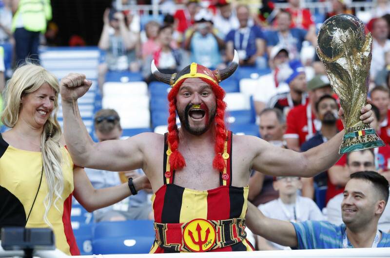 A Belgium supporter holds a replica of the trophy on the stands before the group G match between England and Belgium. Photos: AP Photo/Alastair Grant