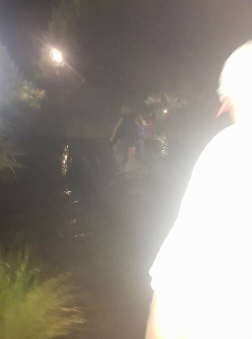 Rachael Innes took this photo of people wading across the Cudgegong River instead of waiting for the suspension bridge on Saturday night. Photo: RACHAEL INNES/ FACEBOOK