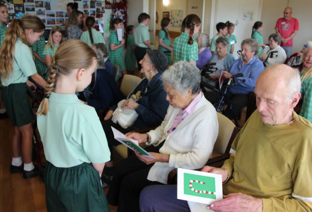 Students from Cudgegong Public School handing out Christmas cards to residents at Mudgee's Pioneer House.