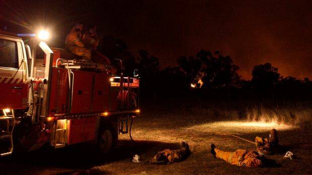 NSW RFS: Crew members from Cumberland Stike Team take a well earned rest after  fighting a large grass fire burning towards Wollar. Photo: Wolter Peeters. 