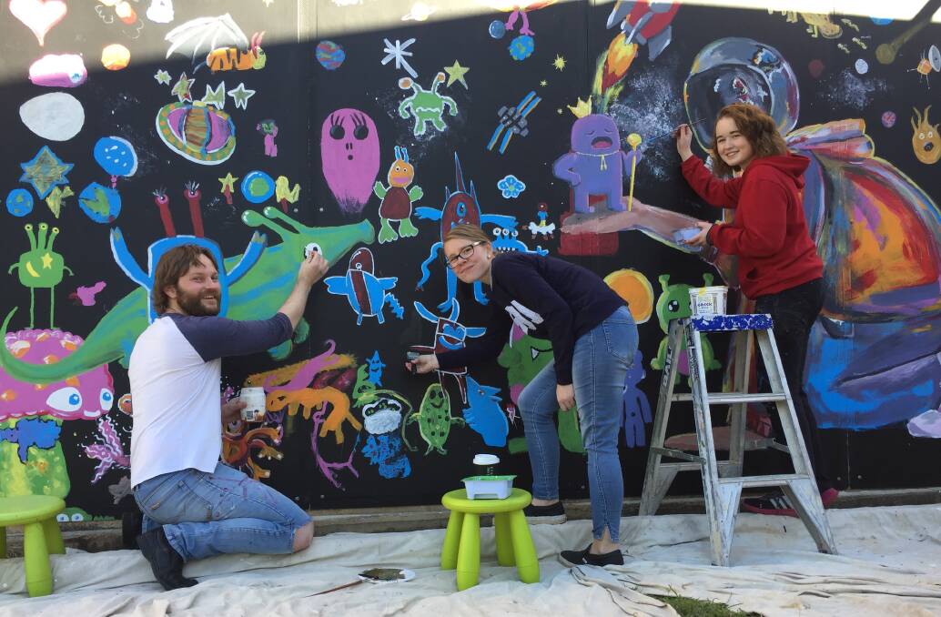 Student Milla Jones (right) encouraged the community to help paint a space-themed mural as part of her Max Potential community project.