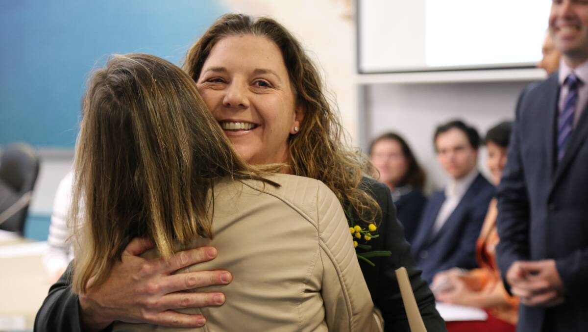 Port Stephens councillor Sarah Smith embraces Julie Jennings as she presents her with an Australian citizenship certificate in Raymond Terrace on September 17.