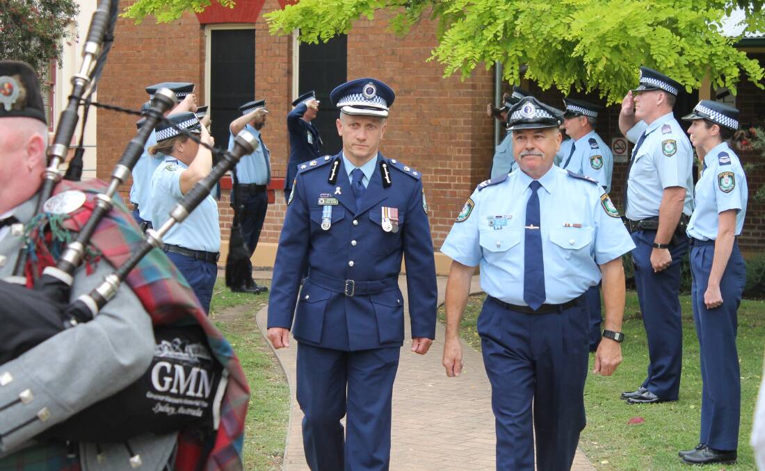 Retired Senior Constable Barry Harris walks the guard of honour out of Mudgee Police Station on his final shift, alongside North West Traffic and Highway Patrol Commander, Superintendent Paul Glinn.